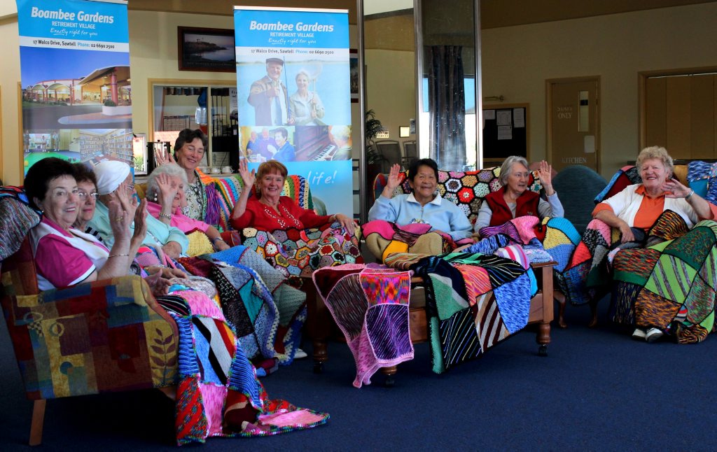 Boambee Gardens residents and a selection of the wonderful blankets they’ve knitted. Boambee Gardens residents and a selection of the wonderful blankets they’ve knitted.